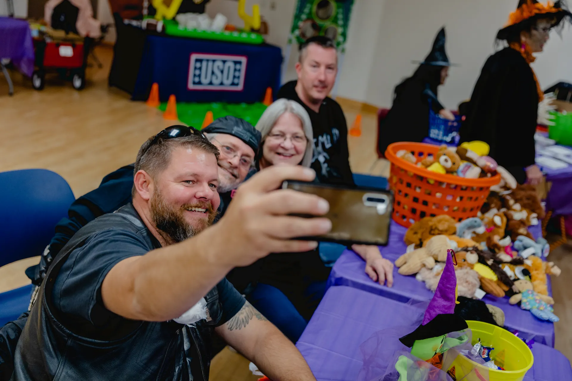 Families and volunteers smiling together at a past Fall Family Festival trunk-or-treat table
