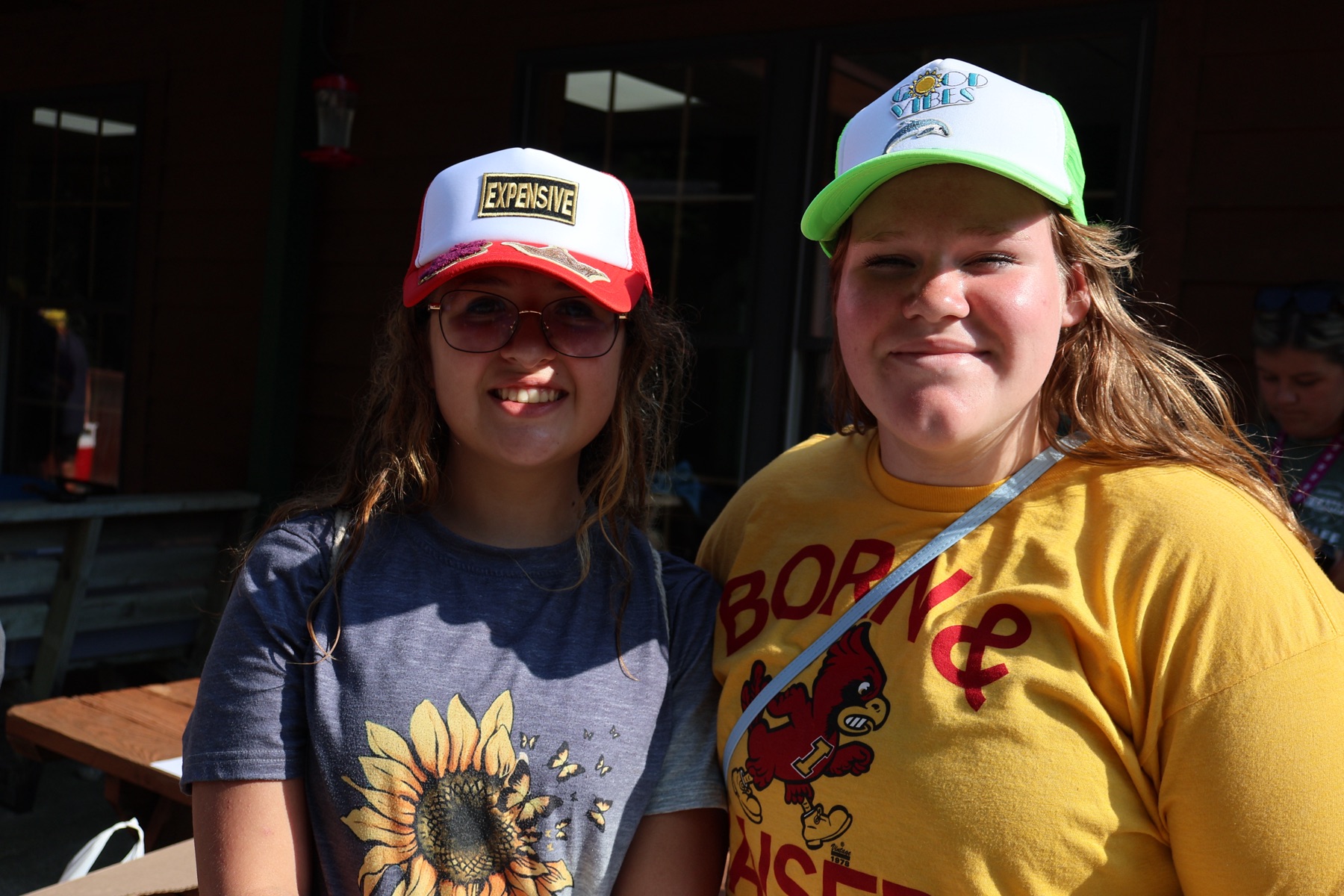 Two campers showing the colorful hats they decorated during summer camp