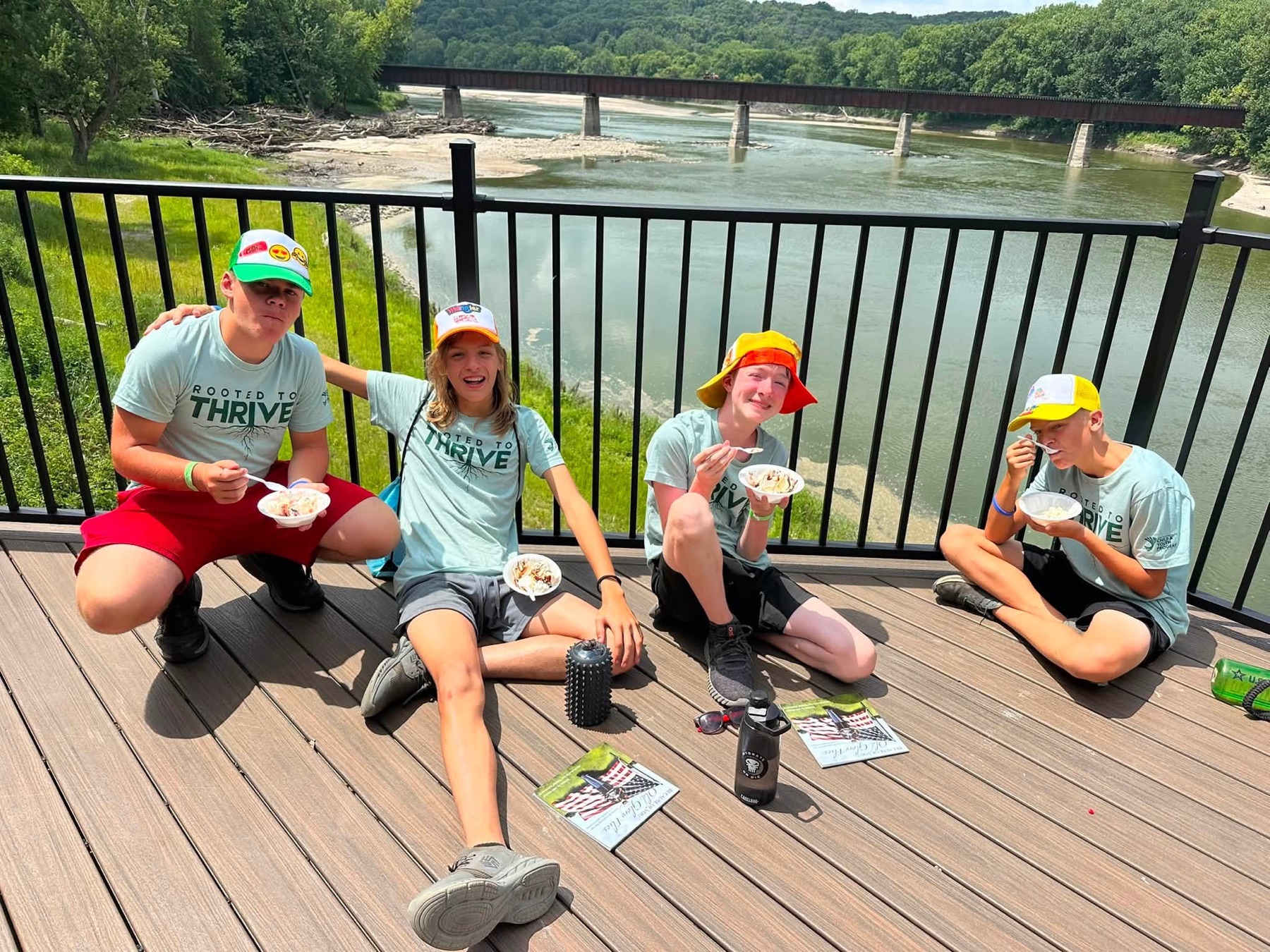 Campers sharing ice cream beside the river during a community visit