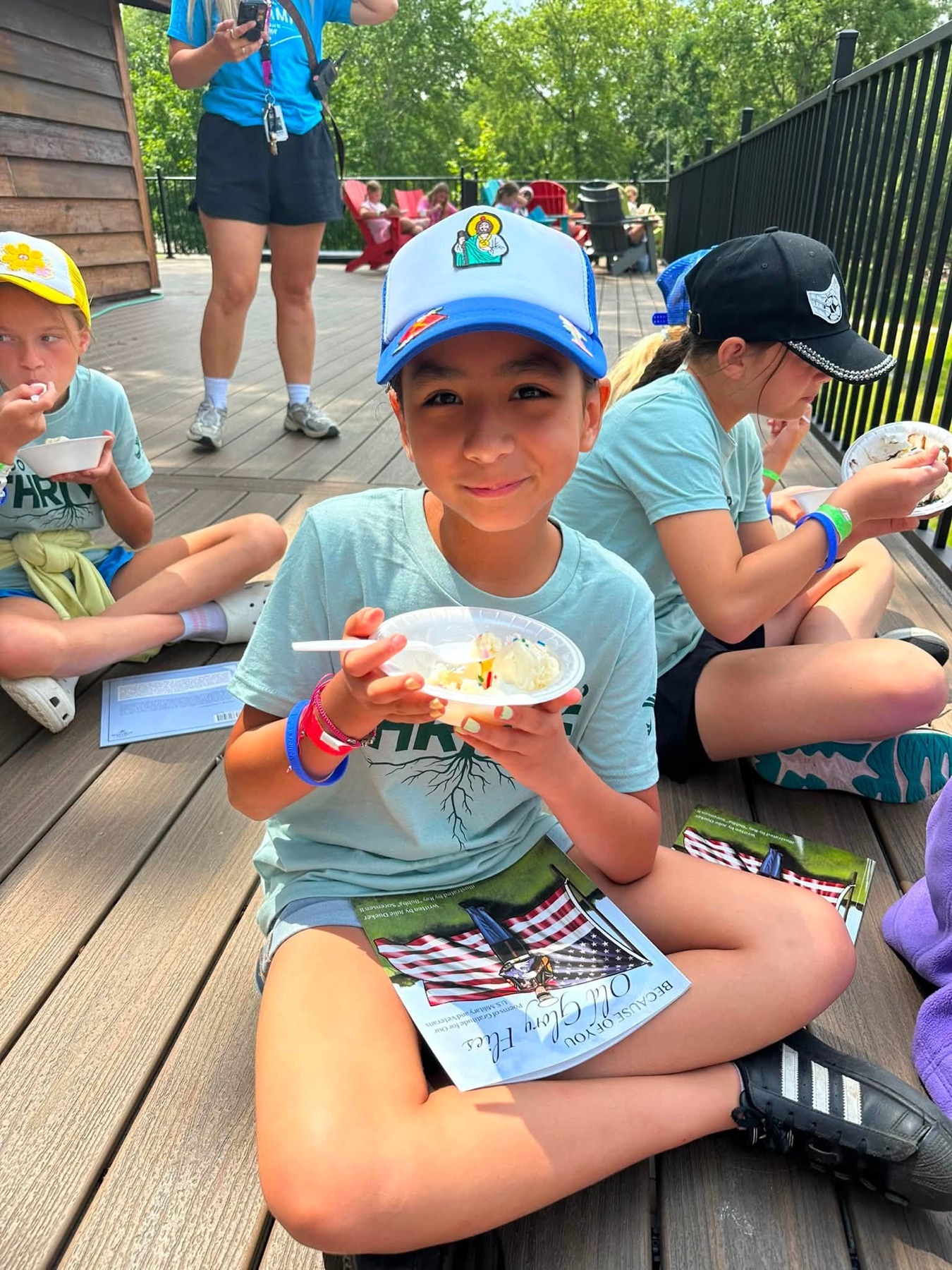 A smiling camper enjoying ice cream and time with cabinmates