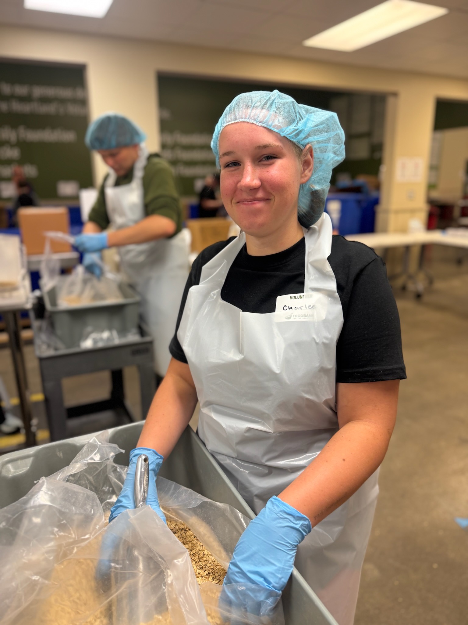 Charlee Cromwell volunteering at a food packaging line